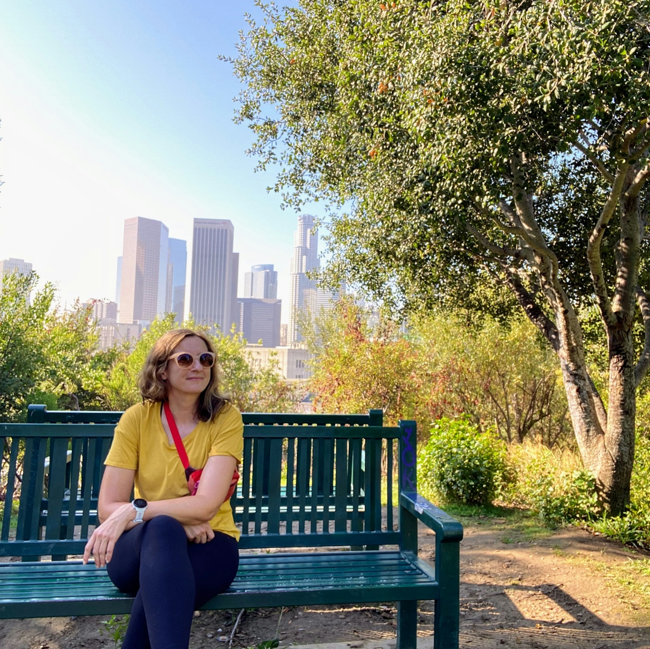 Woman sitting on a bench overlooking the Los Angeles downtown skyline in Vista Hermosa Park Echo Park