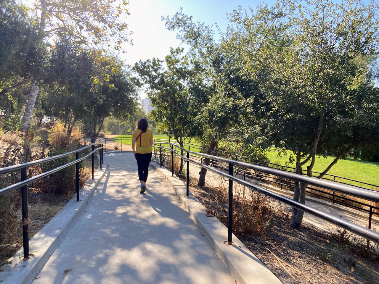 Woman walking a treelined pathway in Vista Hermosa Park Los Angeles 