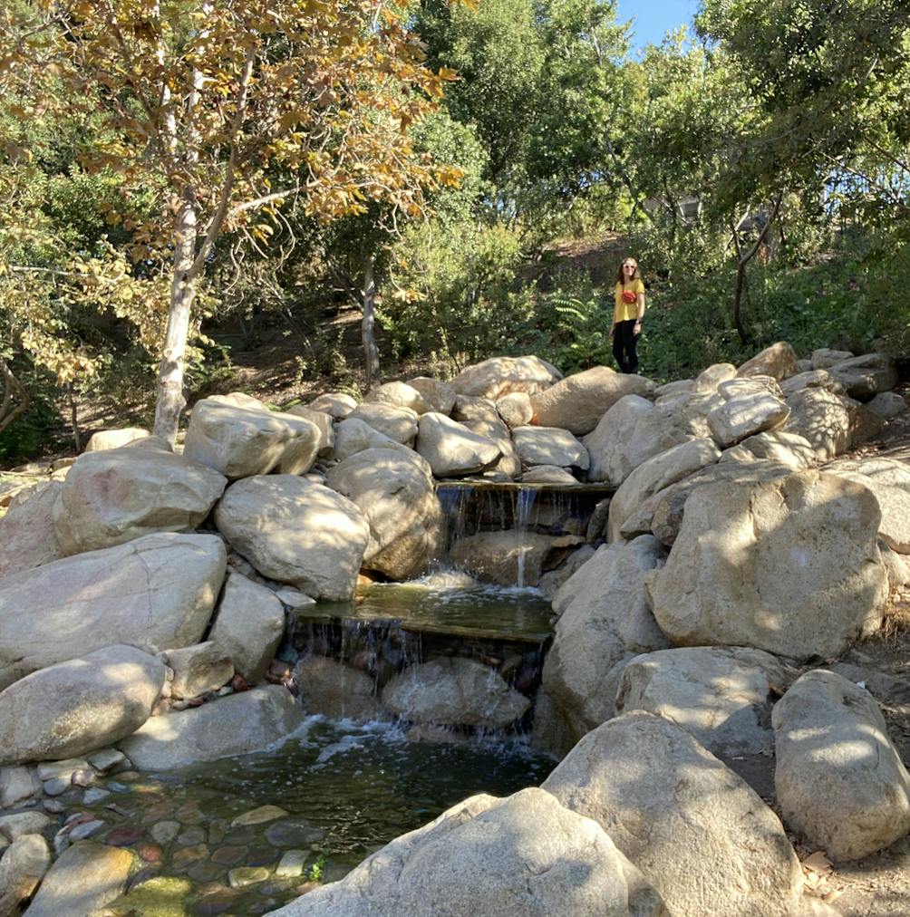 Woman standing above a small waterfall in Vista Hermosa Park Los Angeles 