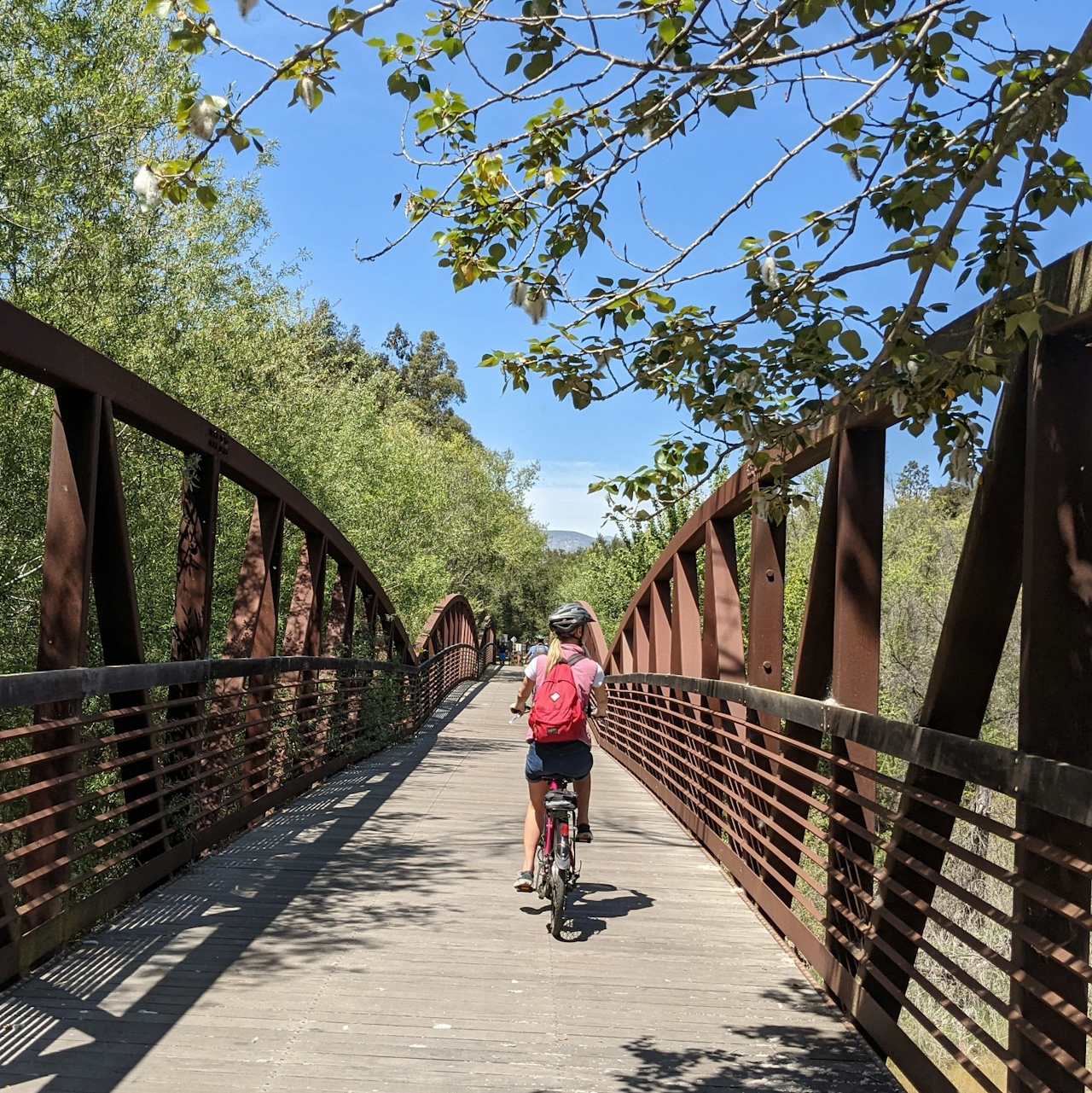 Woman riding her bike over a bridge on the Ventura to Ojai bike path 