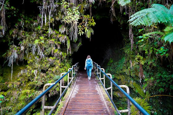 Hiker walking into the Thurston Lava Tube in Hawaii Volcanoes National Park 