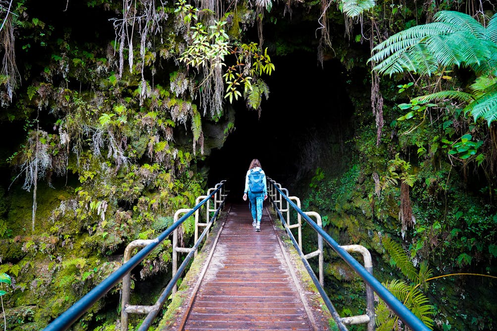 Hiker heads into Thurston Lava Tube at Hawaii Volcanoes National Park 