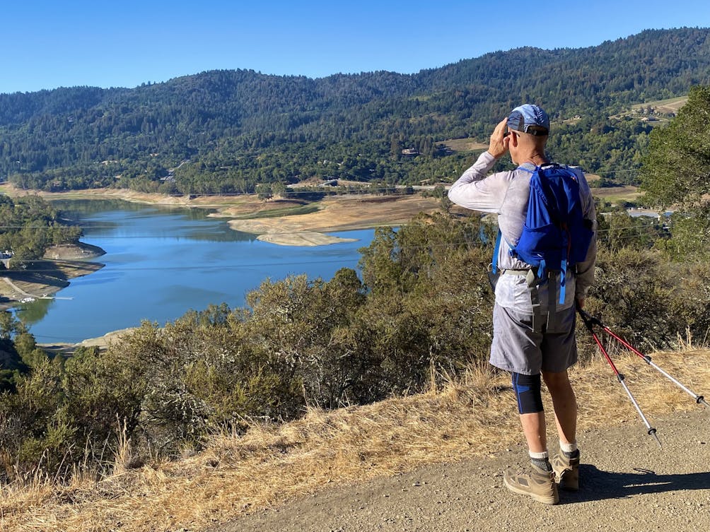 Hiker looking out to the Lexington Reservoir from the high point of St. Joseph's Hill in Los Gatos 