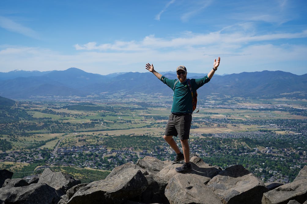 hiker with hands up in the air at Roxy Ann Peak in Medford 