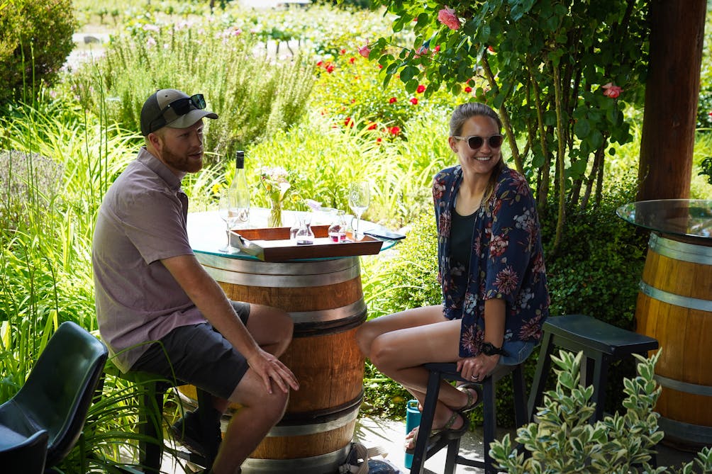 Two people enjoying a wine tasting in the gardens of Wooldridge Creek Winery and Creamery in Grants Pass Southern Oregon