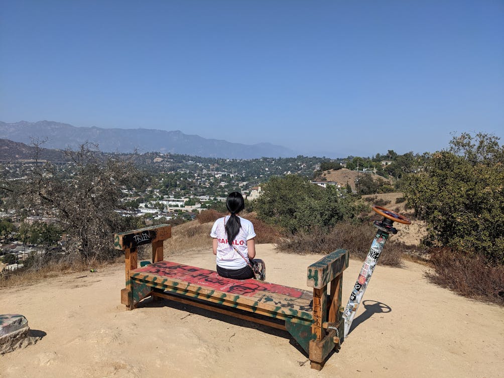 Hiker sitting at bench at summit of Fiji Hill in Los Angeles 