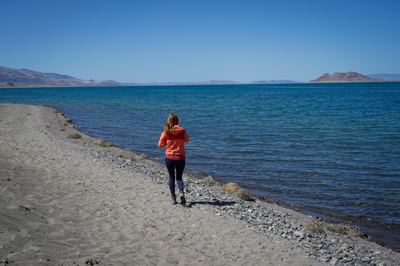 A woman wanders along a beach shoreline at Pyramid Lake in Nevada