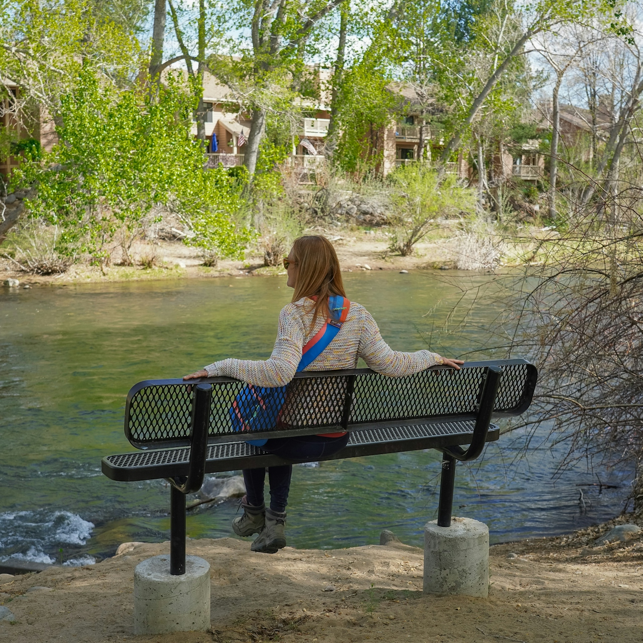 A woman sits on the bench overlooking the Truckee River at Oxbow Nature Study Area 