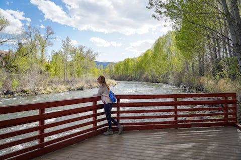 A woman on the overlook deck overlooking the Truckee River at Oxbow Nature Study Area in Reno 