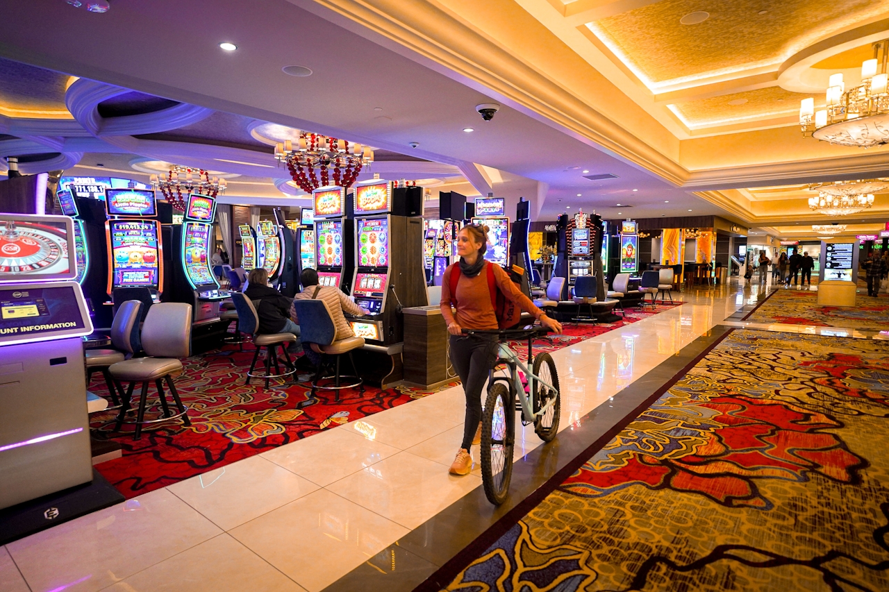 A woman is walking her mountain bike through the casino area of slot machines at Grand Sierra Resort in Reno Nevada 
