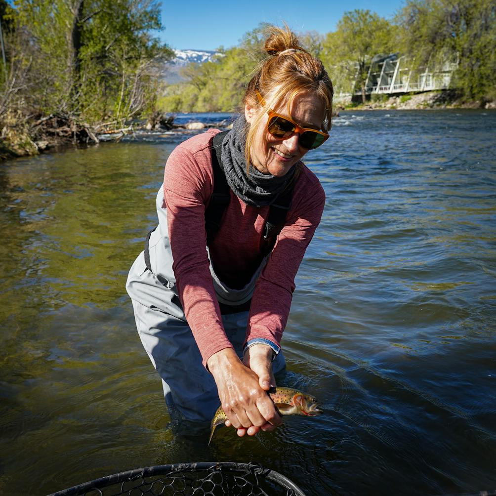 A woman in the Truckee shows a fish she caught with Reno Fly Shop guides 