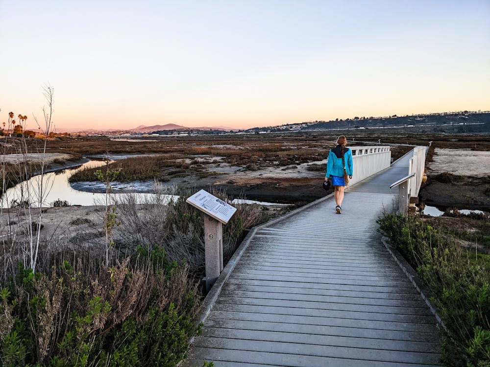A woman walks along the boardwalk next to San Dieguito Lagoon in Del Mar San Diego