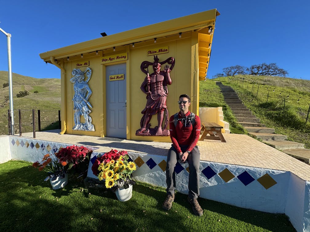 A man takes a break at a temple spot on a hike at Dragon Mountain in Milptas