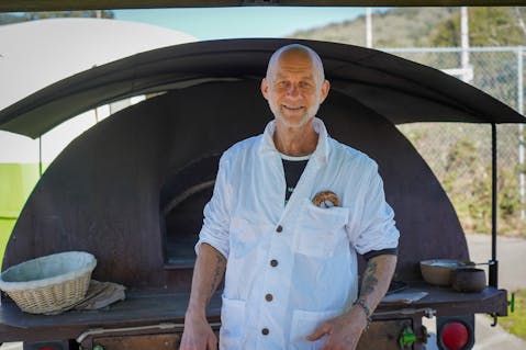 Mike Zakowski (aka Mike the Baker) standing in front of his wood-fire oven at the Sonoma Valley Farmers' Market