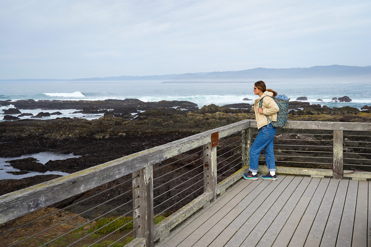 A woman standing on a deck overlooking the tidepools and Pacific at MacKerricher State Park in Mendocino 