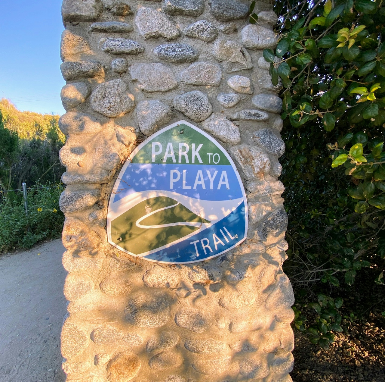 A stone gate and a plaque sign indicating the Park to Plays Trail in Culver City 
