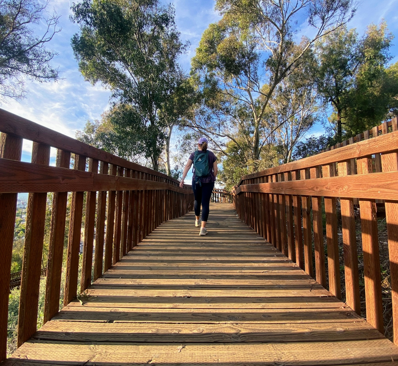 A woman walking on a boardwalk that is part of the Park to Playa Trail in Culver City 
