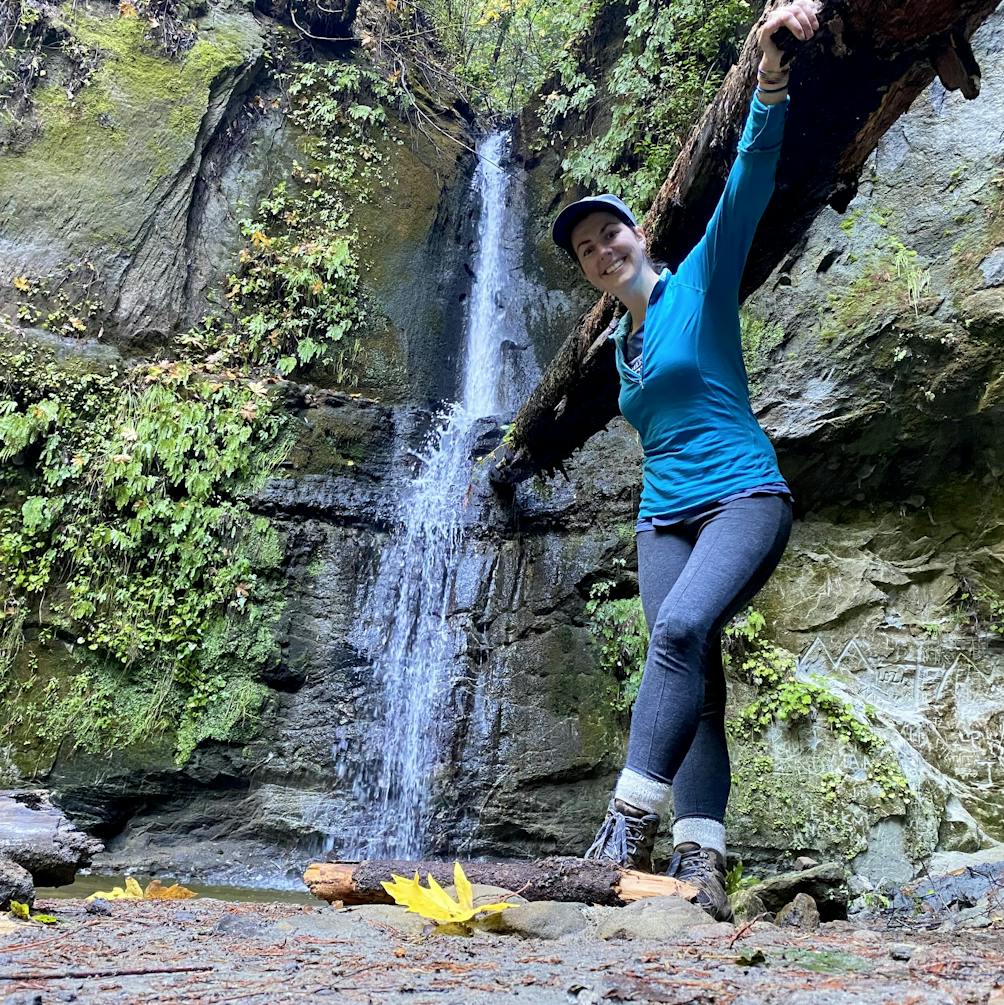 Hiker posing in front of Maple Falls at The Forest of Nisense Marks State Park