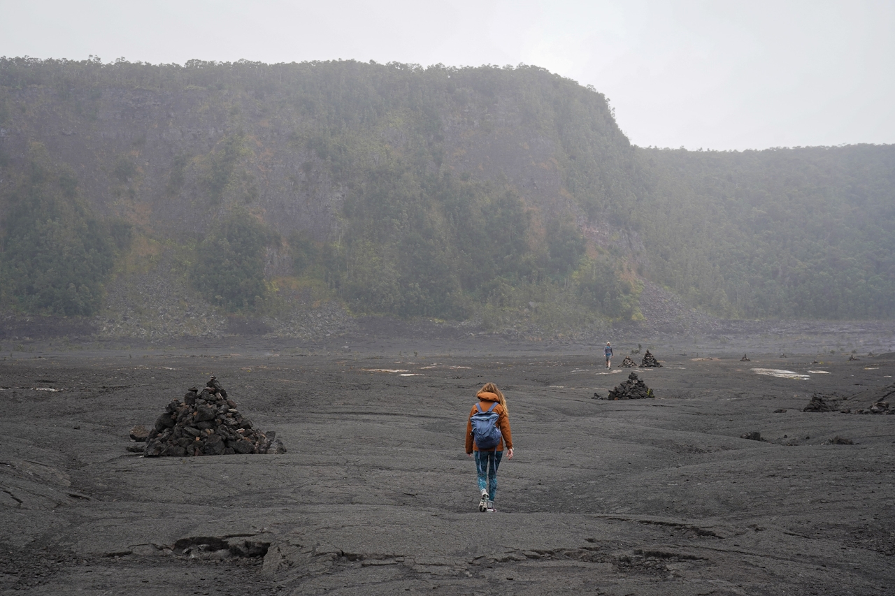 Hiker walking across the ancient lava bed in Hawaii Volcanoes National Park 