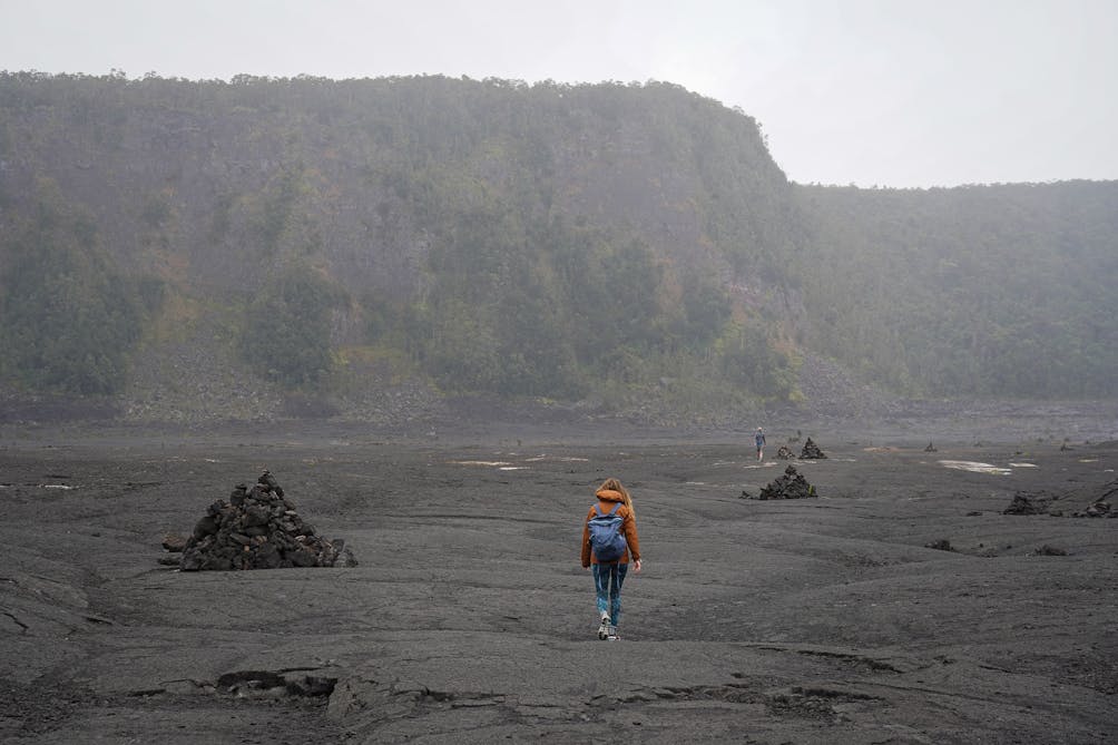Hiker walking across the ancient lava bed in Hawaii Volcanoes National Park 