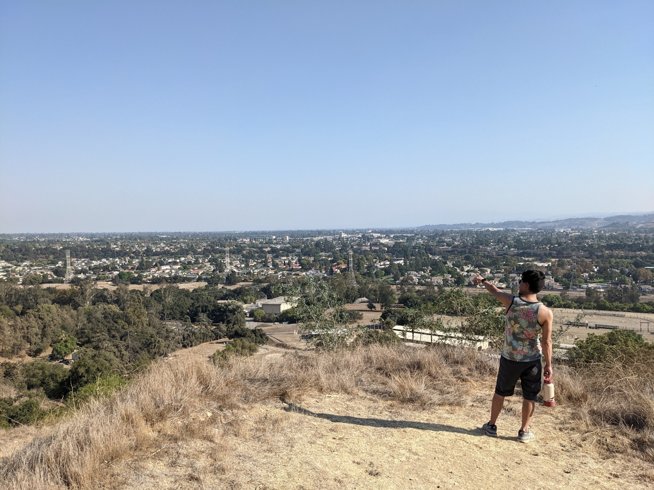 Hiker pointing out to valley views on a hiking trail at Horsethief Canyon Park in San Dimas