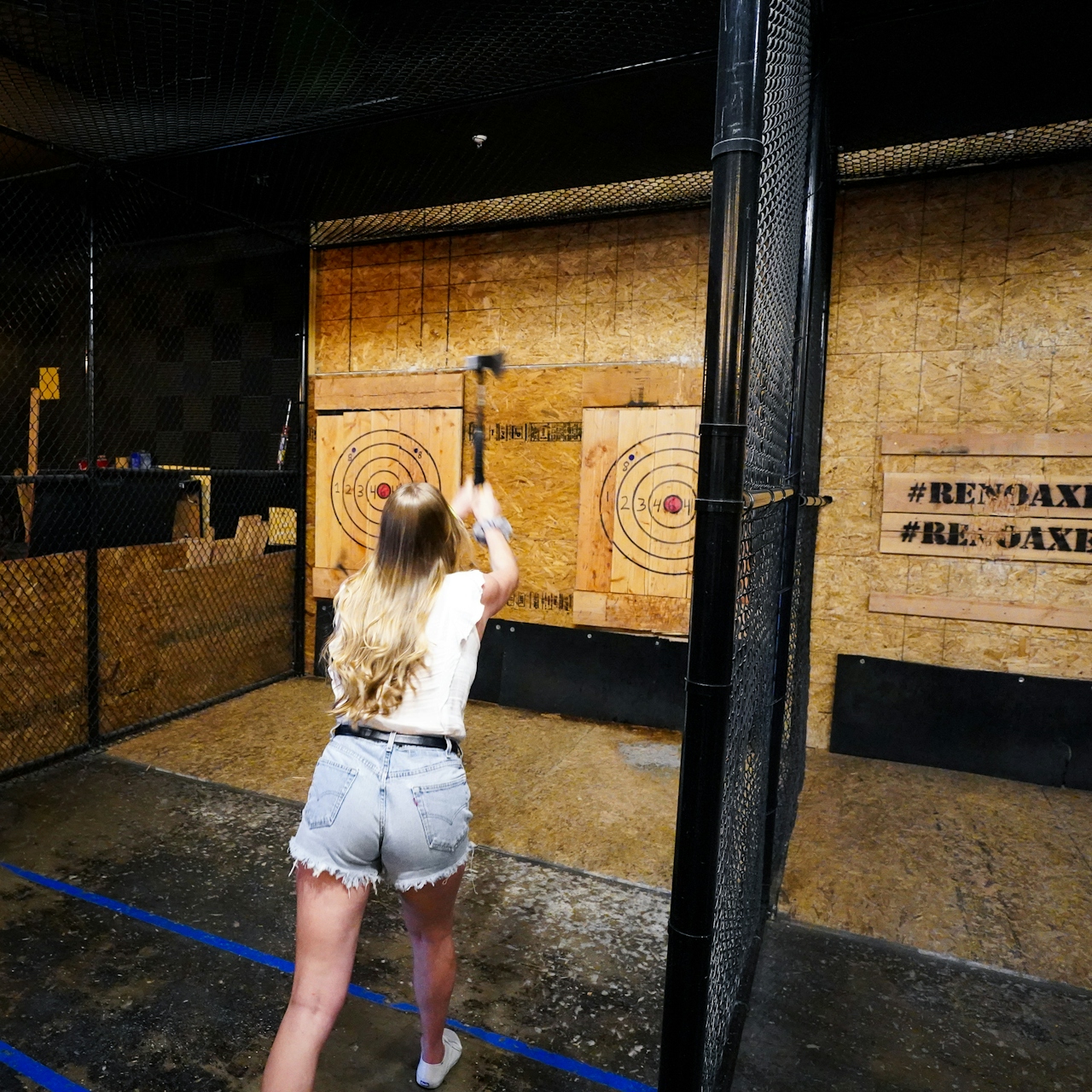 woman throwing axe at Reno Axe