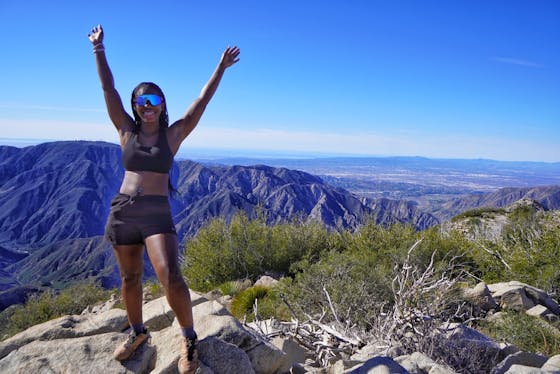 Hiker celebrating with raised arms after reaching Condor Peak in the San Gabriel Mountains 