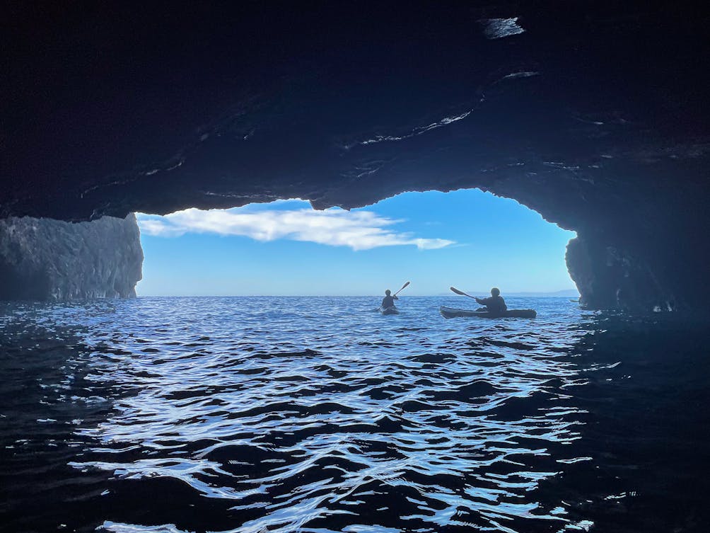 Cave kayaking at Channel Islands National Park, two kayakers outside a cave at Santa Cruz Island 