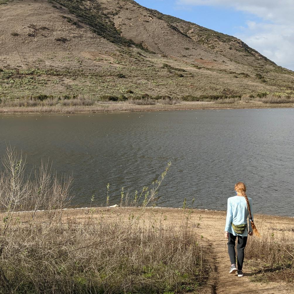 Woman walking up to the the shoreline at Lake Hodges Escondido San Diego County 