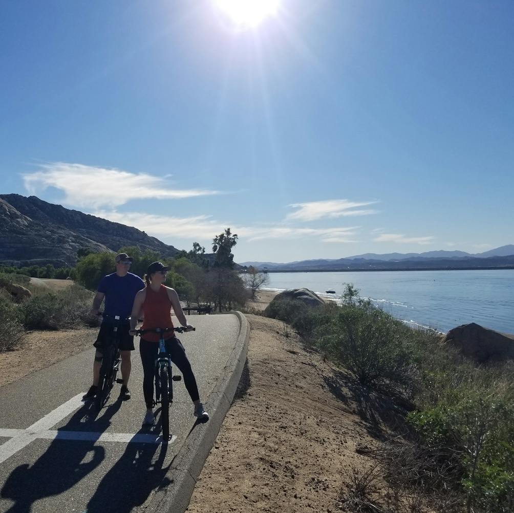Two bikers on the paved bike path at Lake Perris State Recreational Area in the Inland Empire 