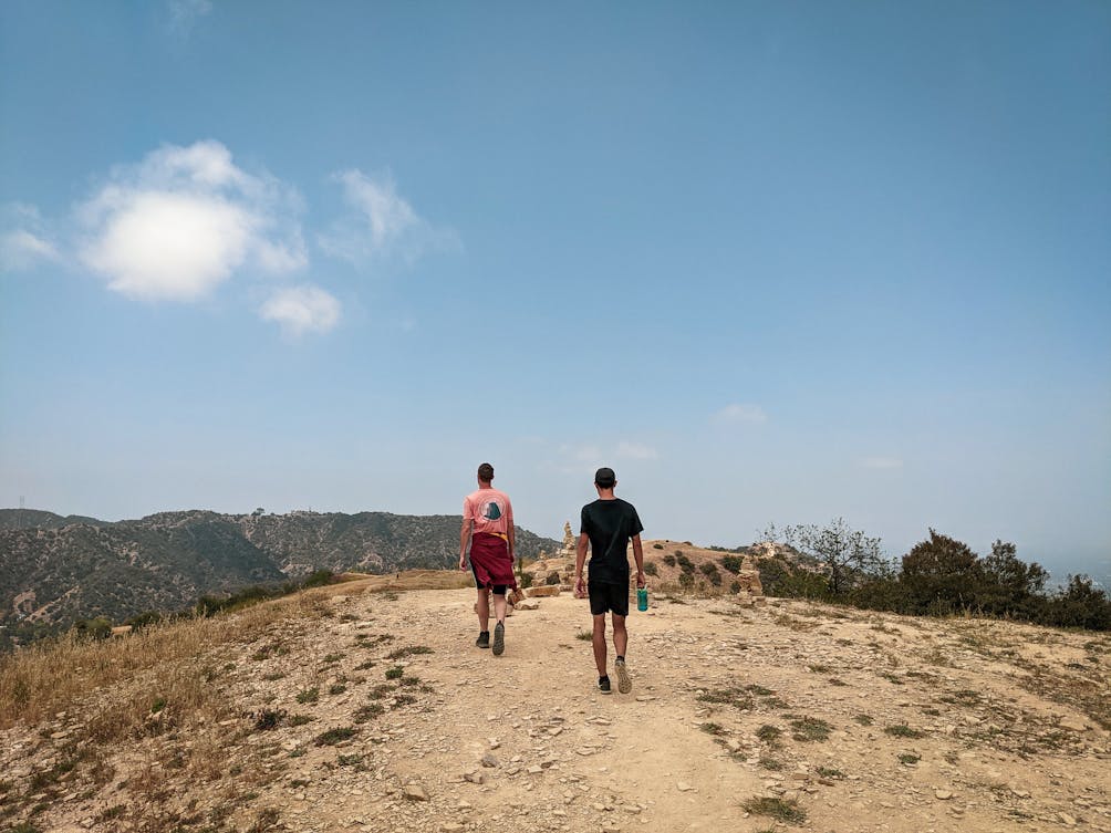 Two hikers coming to the crest of a trail at Upper and Lower Canyonback Trails in Los Angeles county 