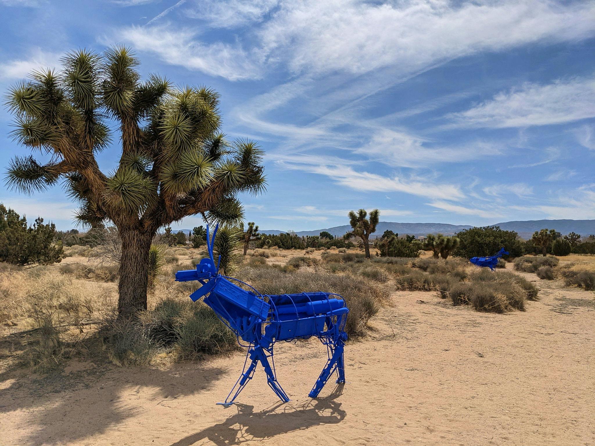 Blue art installation of deer near a Joshua Tree in the Antelope Valley