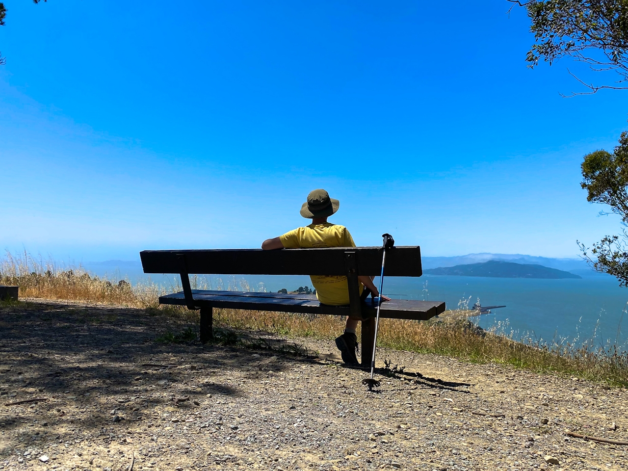 Person sitting at a bench overlooking the Golden Gate and Angel Island from Miller Knox Regional Shoreline East Bay 