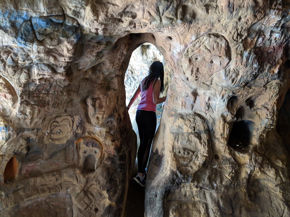 Hiker going through Vanalden Cave in the Santa Monica Mountains