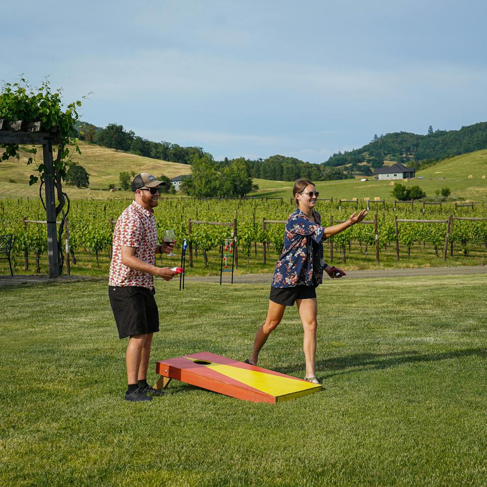A man and woman enjoy a game of ladder toss on the grounds of Abacela Winery near Roseburg 