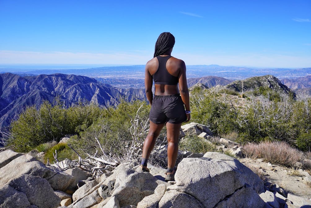 Hiker standing at Condor Peak overlooking the scenery and San Gabriel Mountains 