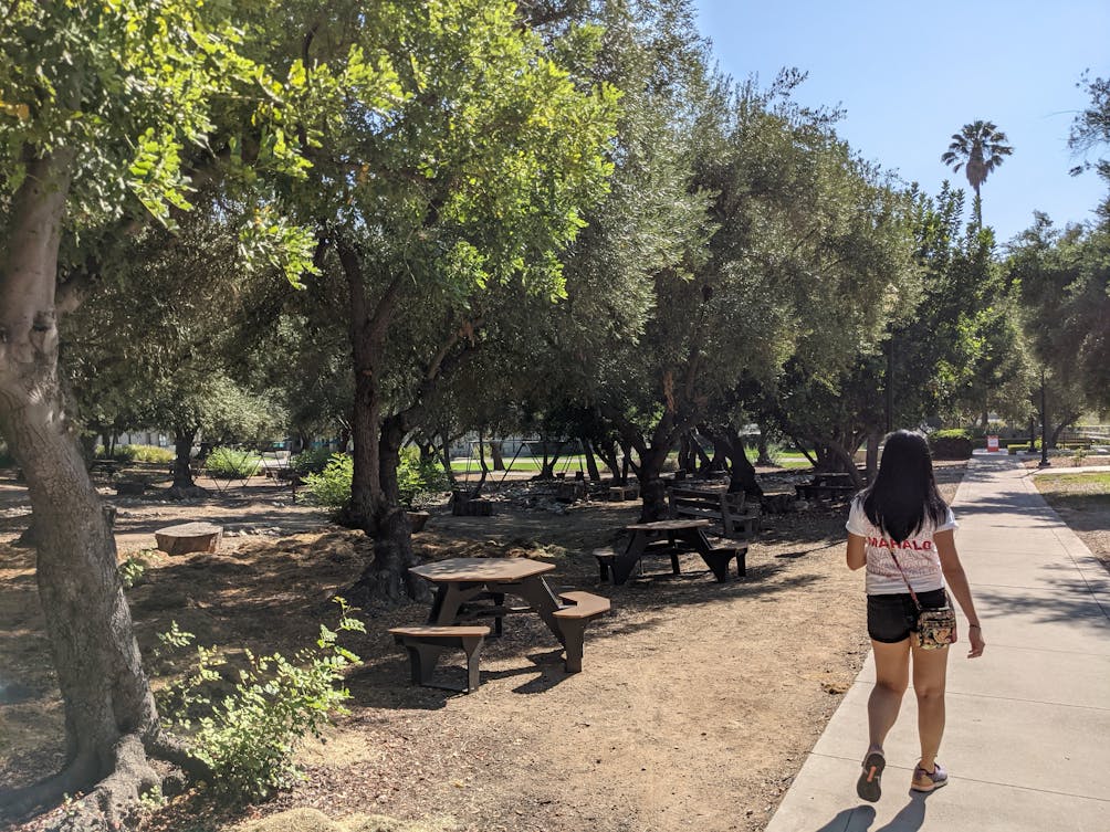 Woman walking the campus by picnic tables at Occidental Campus in Los Angeles 