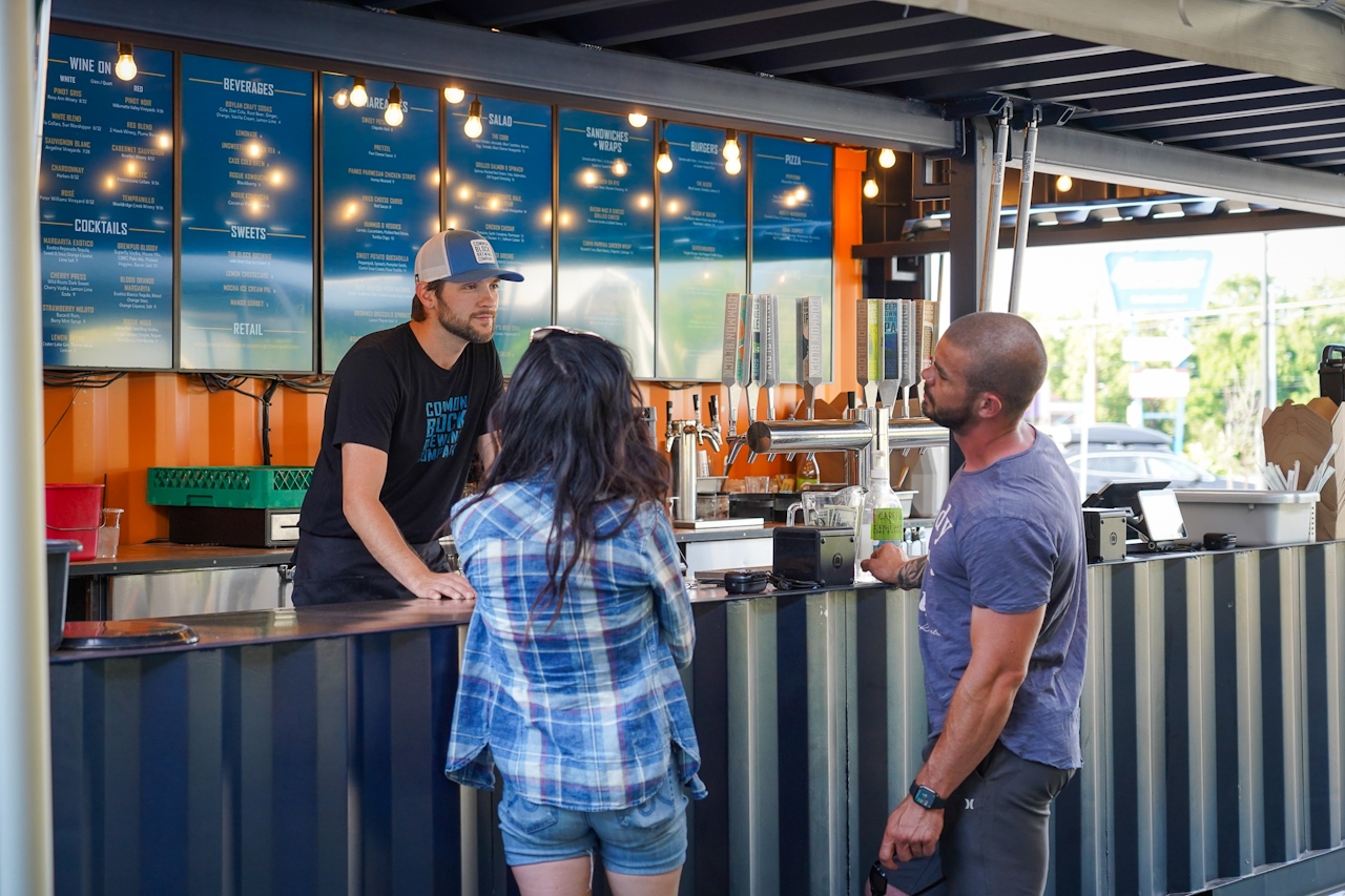 Two people at the bar at Commonblock Brewing in Medford 