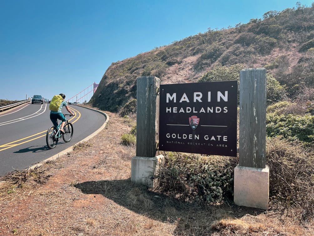 Biker passing the official sign to Marin Headlands Golden Gate in the San Francisco Bay Area