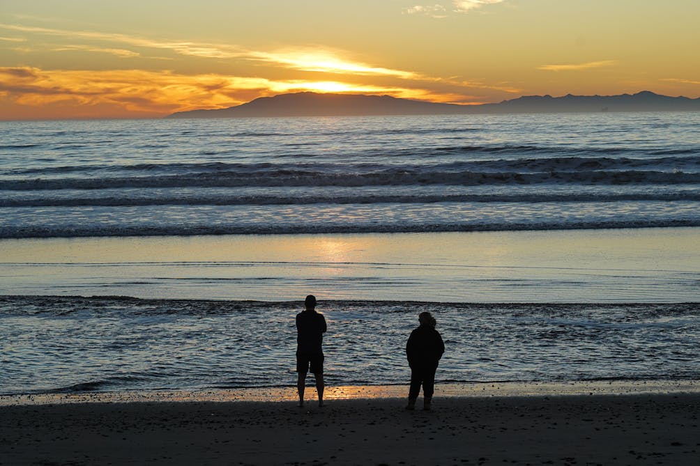 Two people watching the sunset over Channel Islands National Park from Hollywood Beach in Oxnard 