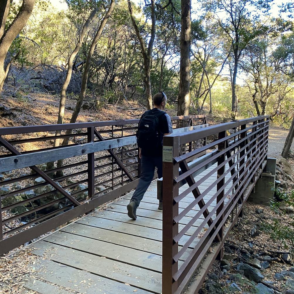Hiker crossing a bridge on the Bay Area Ridge Trail at Mount Umunhum 