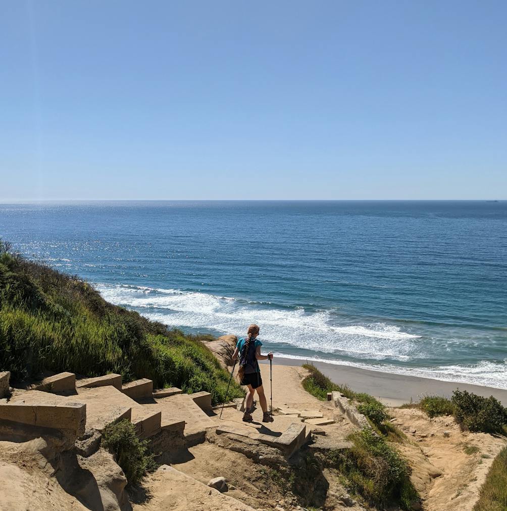 Woman hiking down to Black's Beach in La Jolla San Diego 