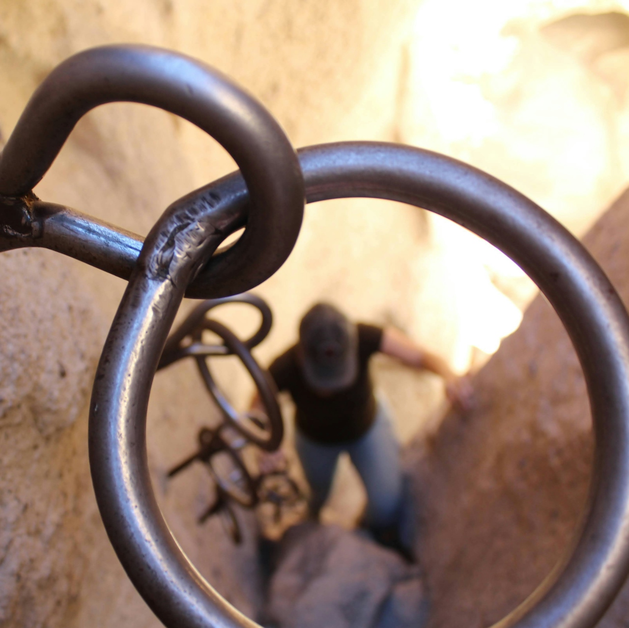 Hiker using ring cables to go up a canyon at hole in the wall rings trail loop in the Mojave Desert 