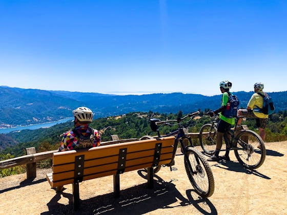 Bikers checking out the view of the reservoir from a bench in El Sereno Open Space Preserve on the Bay Area Ridge Trail