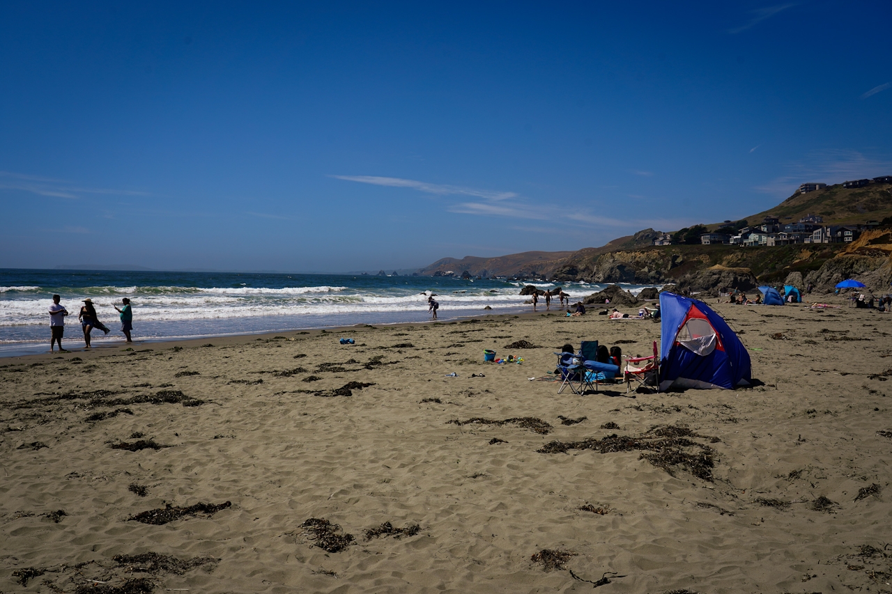 Beach goers hang out on the beach and play in the surf at Dillon Beach in Marin 