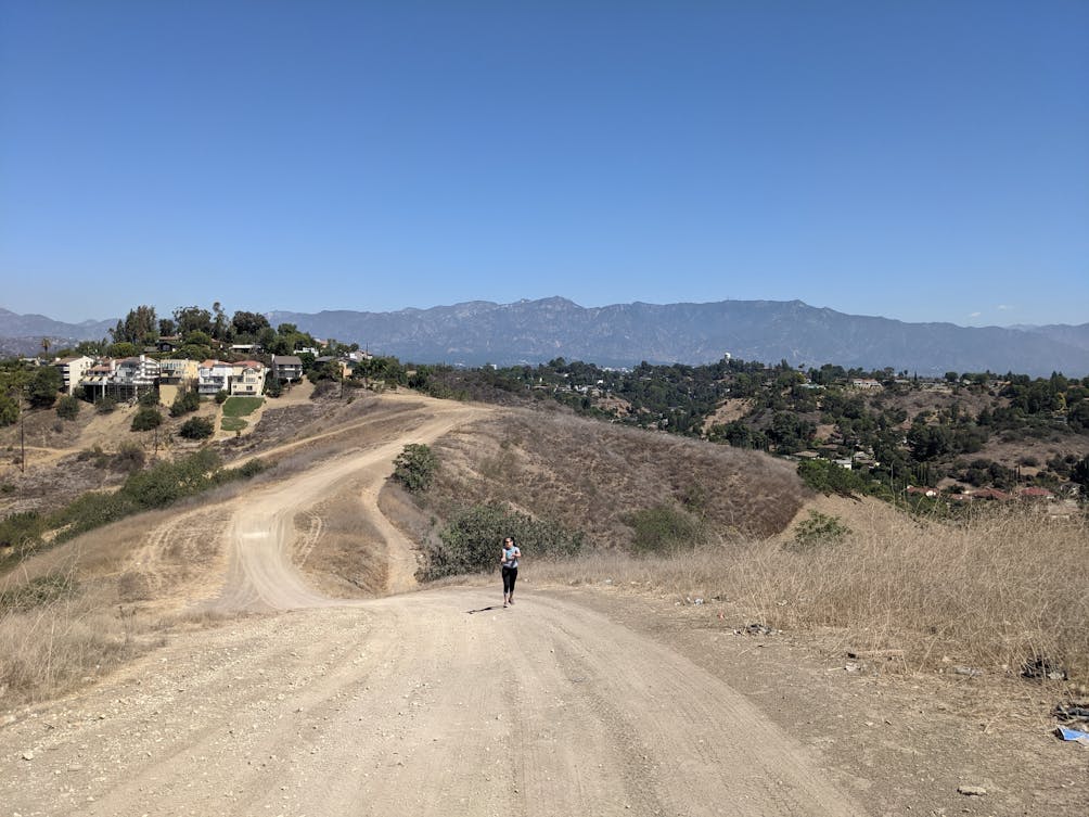Hiker on wide open rolling trail at Elephant Hill Open Space in Los Angeles 
