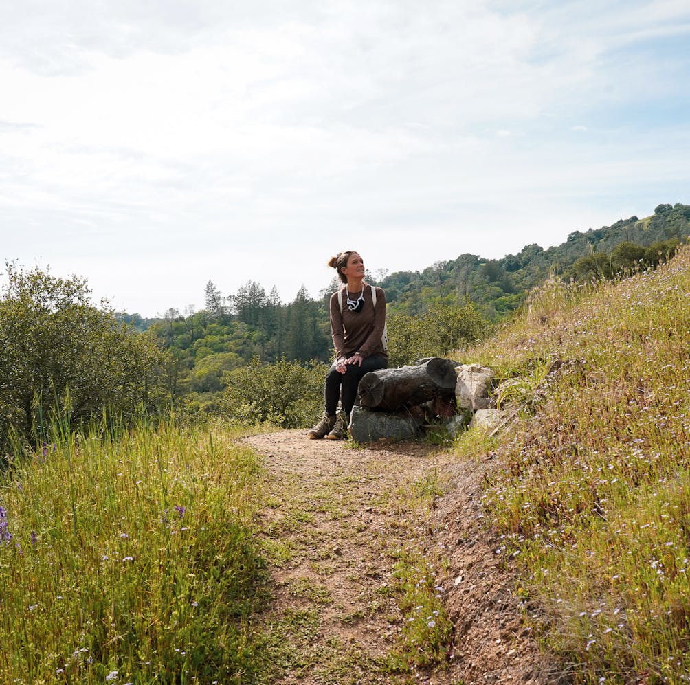 Woman sitting on a bench along Valentine Vista Loop Trail in Moore Creek Napa