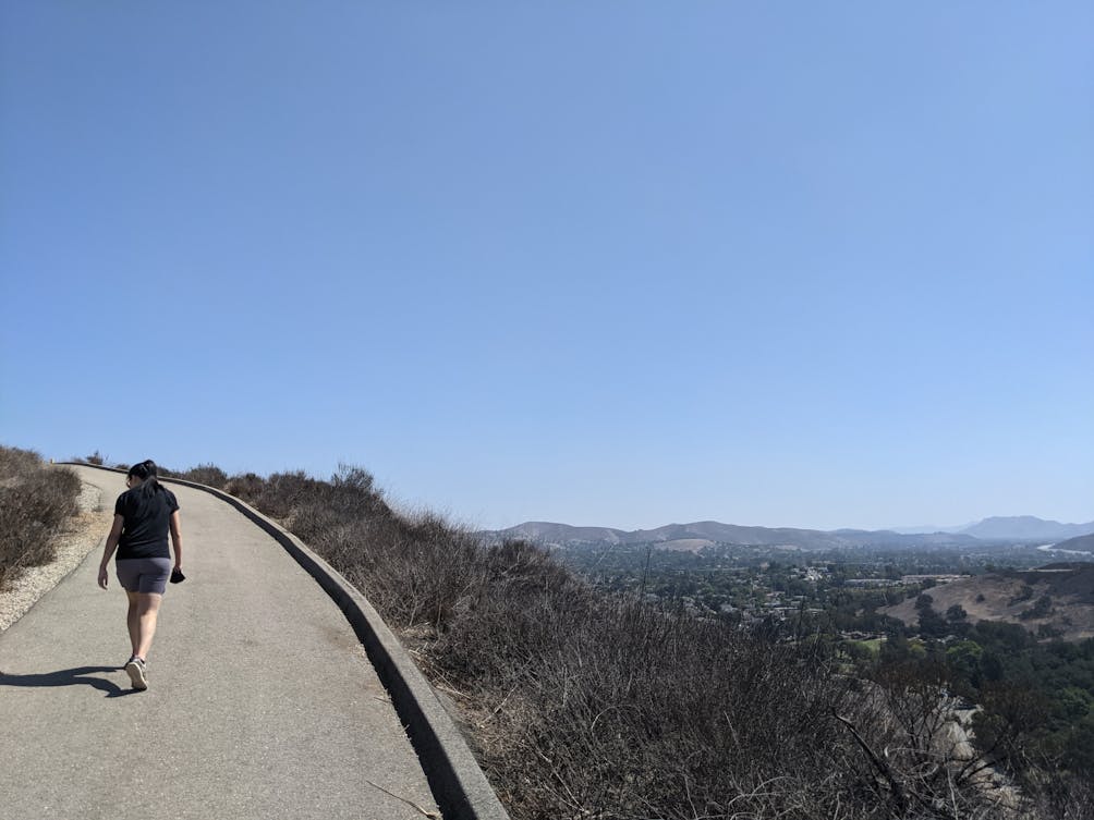 A woman hiking the wide, paved trail at Tarantula Hill in Thousand Oaks California 