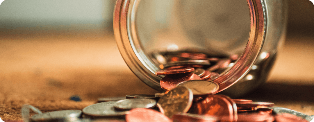 coins from jar spilling onto desk