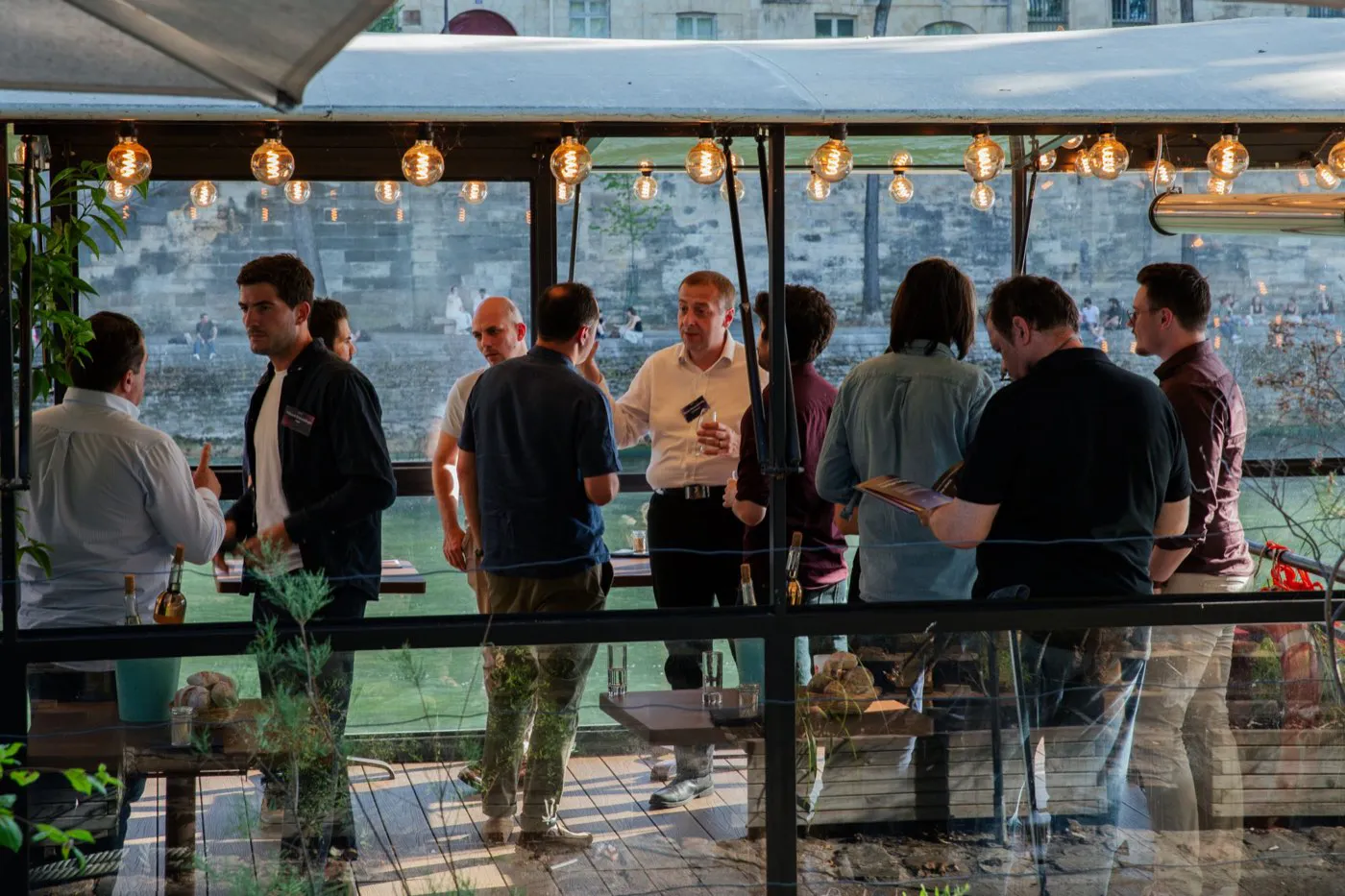Invités échangeant lors d’une soirée Najar au bord de la Seine